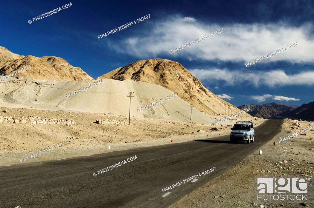 Stock Photo: Jeep with mountain ranges in the background, Ladakh, Jammu and Kashmir, India.