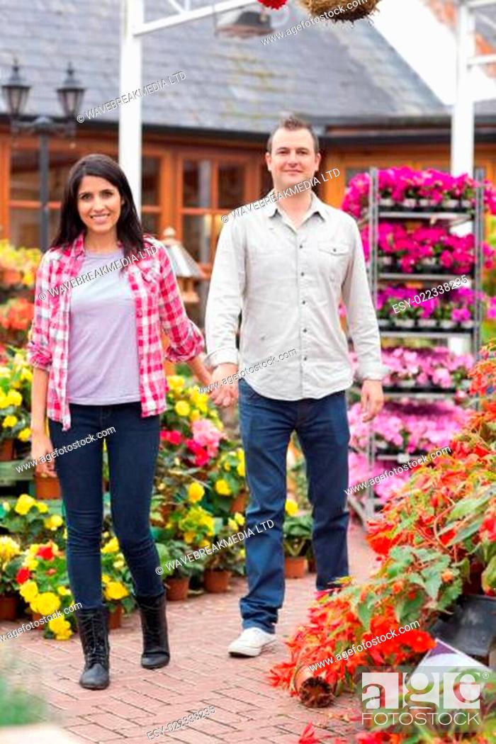 Stock Photo: Couple holding hands walking through garden center.