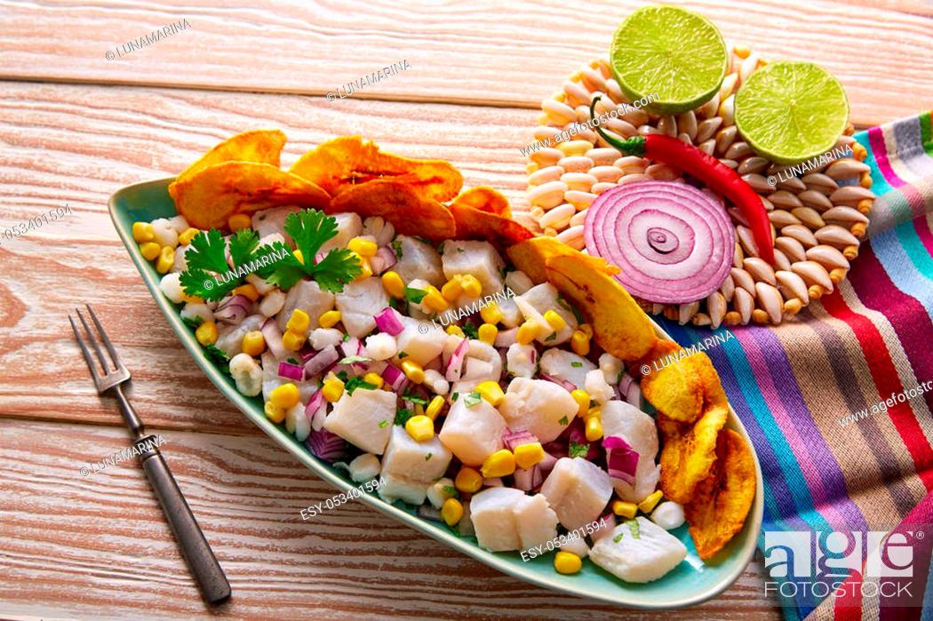 Stock Photo: Ceviche peruvian recipe with fried banana and ingredients on wooden table.