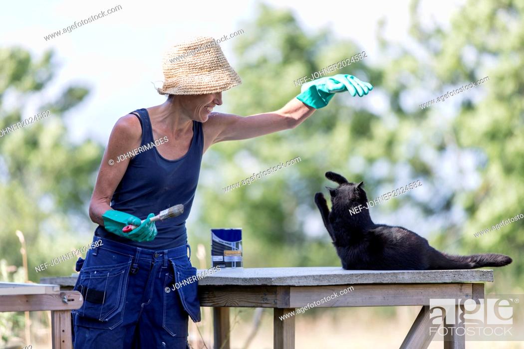 Imagen: Mature woman playing with cat.