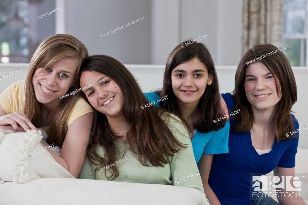 Stock Photo: Portrait of four teenage girls sitting on a couch at home.