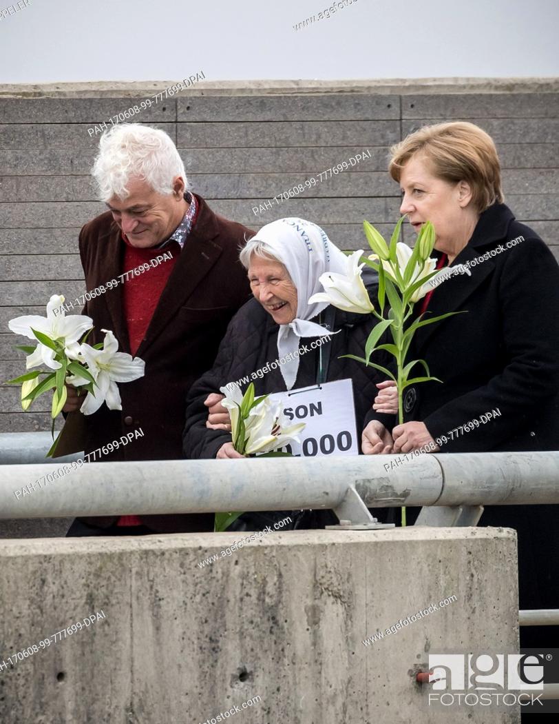 Stock Photo: German Chancellor Angela Merkel (R) holds flowers in her hands as she stands next to Vera Jarach (C), mother of a vanished woman.