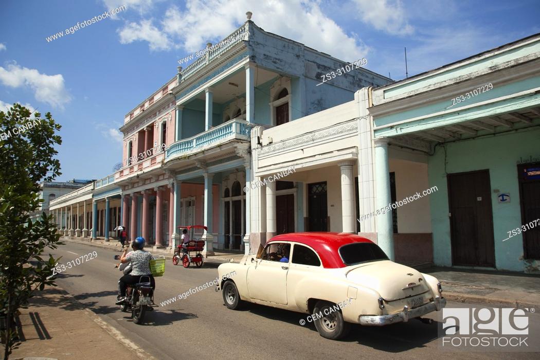 Stock Photo: Old American car, motorcycle and bici taxi at Paseo Del Prado or so called Boulevard in the city center, Cienfuegos, Cuba, West Indies, Central America.