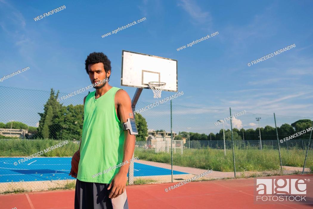 Stock Photo: Young basketball player with ball and arm pocket.