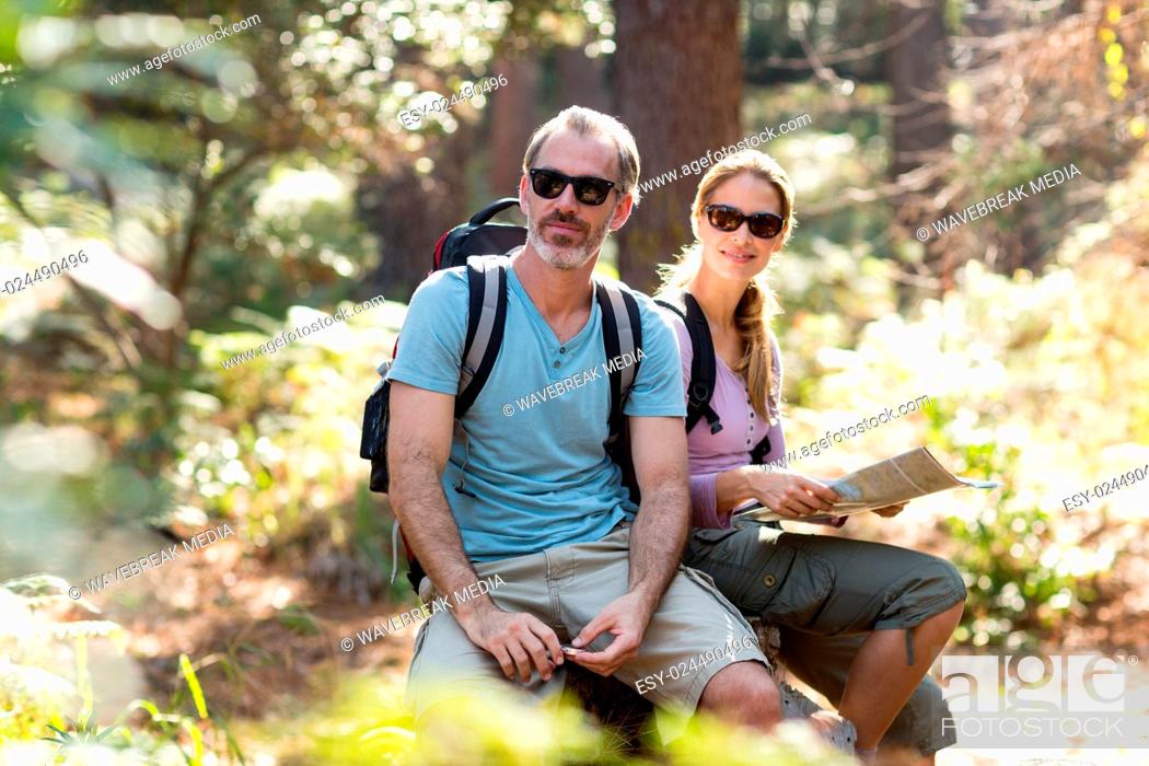 Stock Photo: Hiker couple sitting on rock with map.