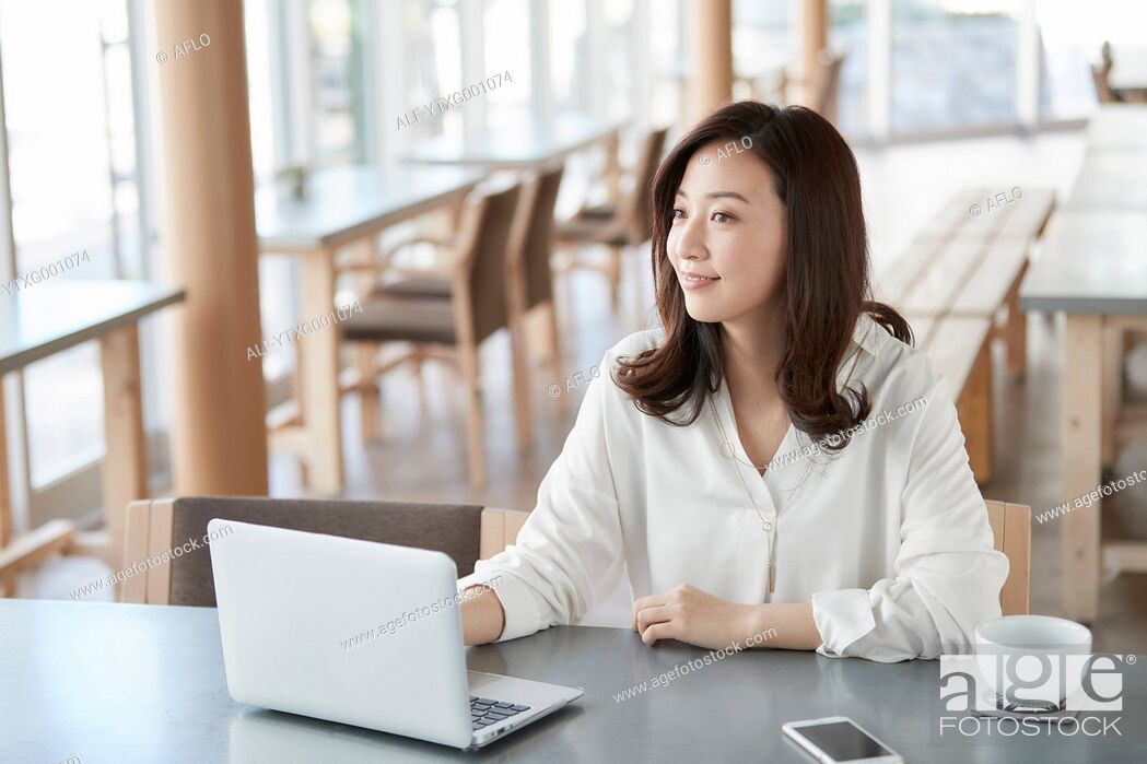 Stock Photo: Japanese woman with laptop in a stylish cafe.