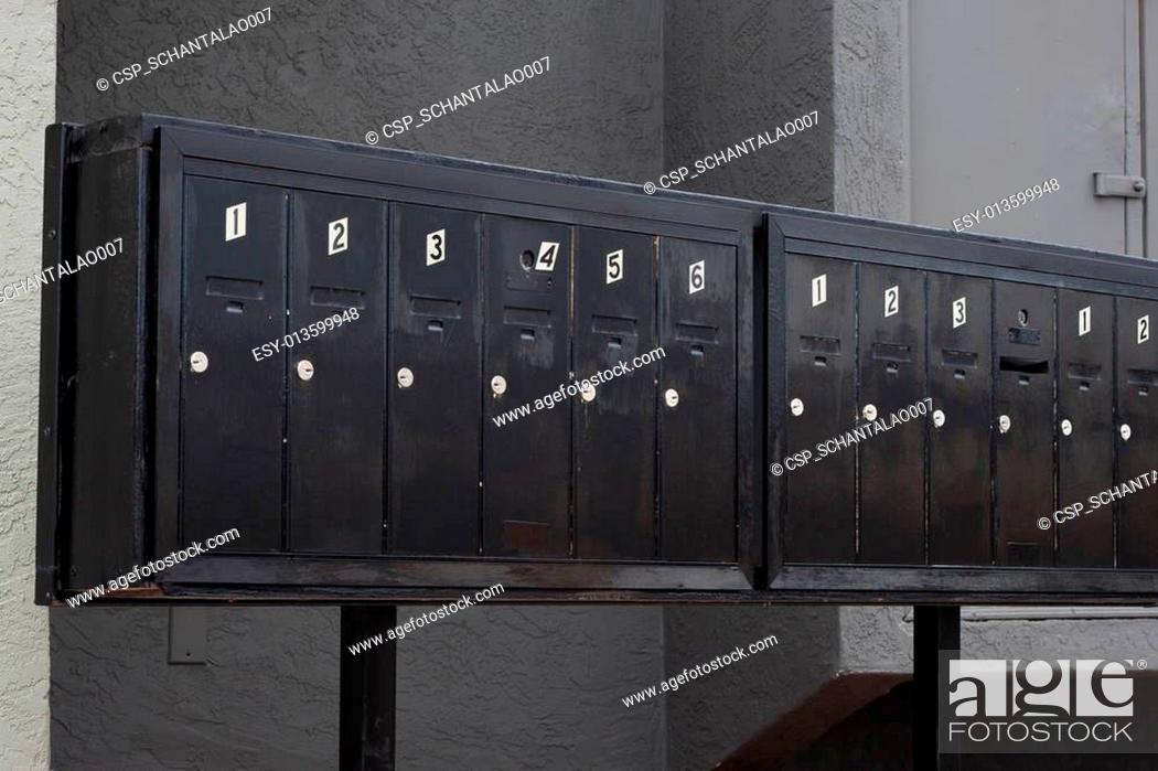 Stock Photo: metallic mailbox array tidy infront of apartment houses.