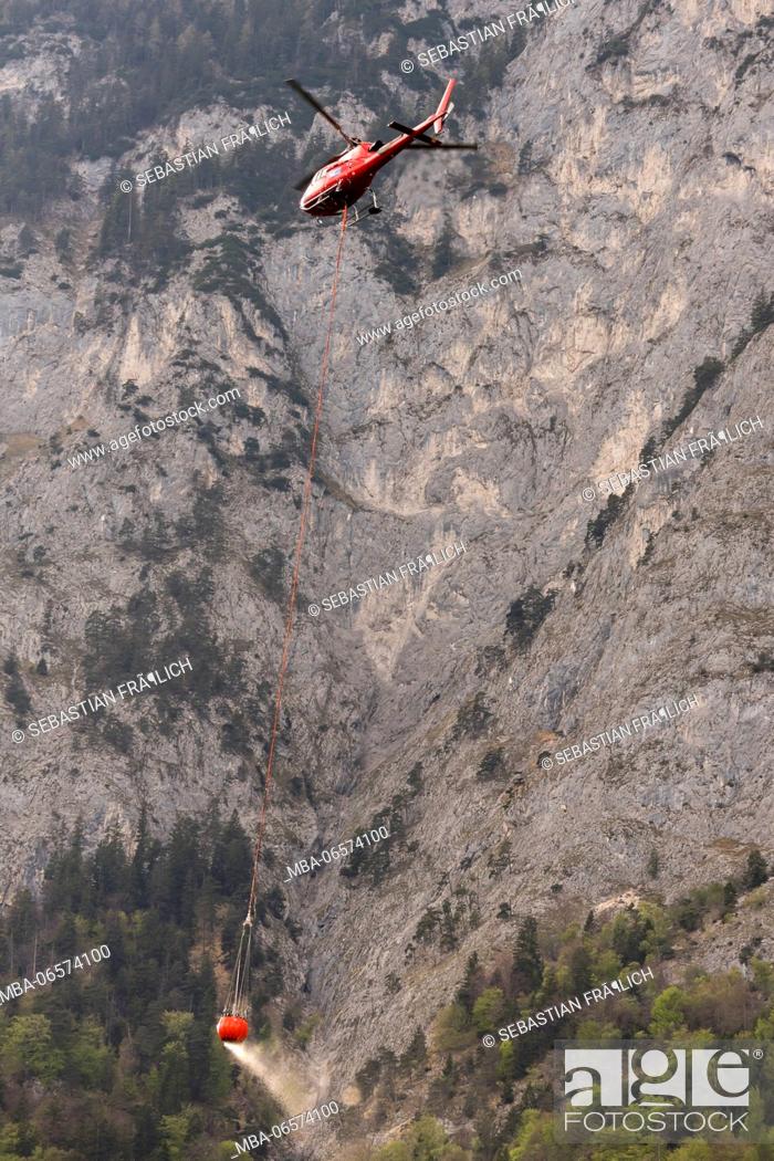 Stock Photo: Helicopter of the Ã–AMTC in forest fire-fighting operation near Innsbruck in Tyrol, Austria.
