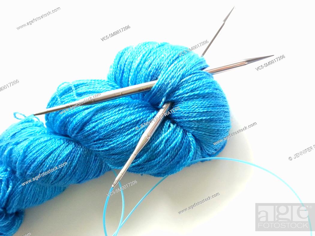 Stock Photo: Close-up of yarn and knitting needles on a white background.