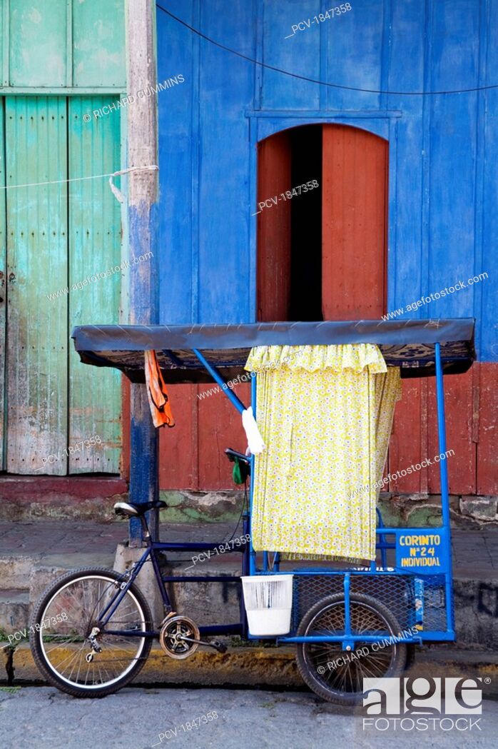 Stock Photo: A tricycle taxi in front of a building.