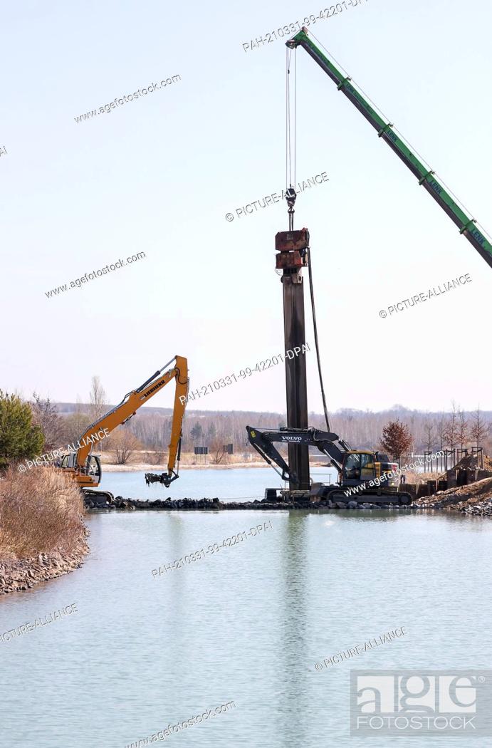 Stock Photo: 31 March 2021, Saxony, Markkleeberg: The canal between the Markkleeberger and Störmthaler lakes is closed off with a sheet pile wall.
