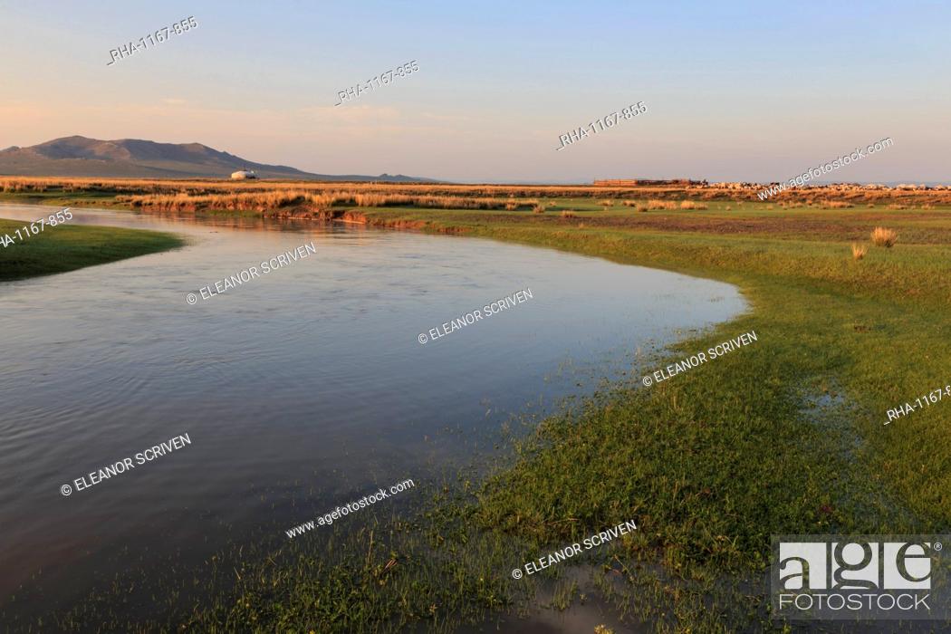 Stock Photo: River flows past ger, stock pen and herd lit by summer sunrise, distant hills, Nomad camp, Gurvanbulag, Bulgan, Mongolia, Central Asia, Asia.
