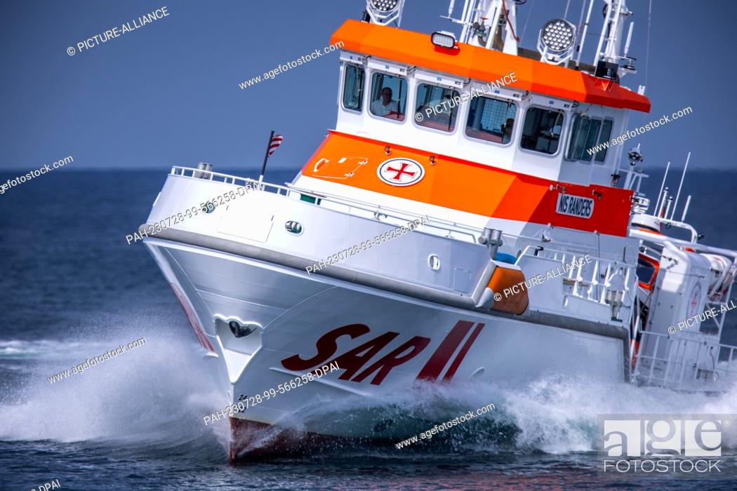 Stock Photo: PRODUCTION - 27 July 2023, Mecklenburg-Western Pomerania, Zingst: The 28-meter-long and nearly 4, 000-horsepower sea rescue cruiser ""Nis Randers"" maneuvers.