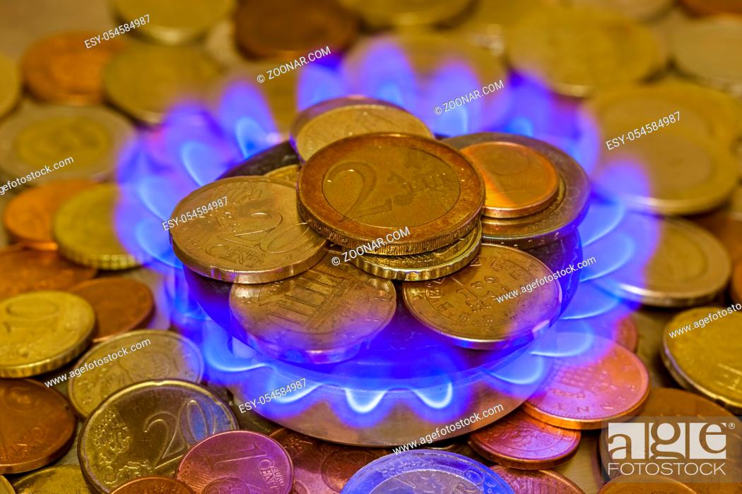 Stock Photo: Coins of on the gas burner of the kitchen stove - business background.