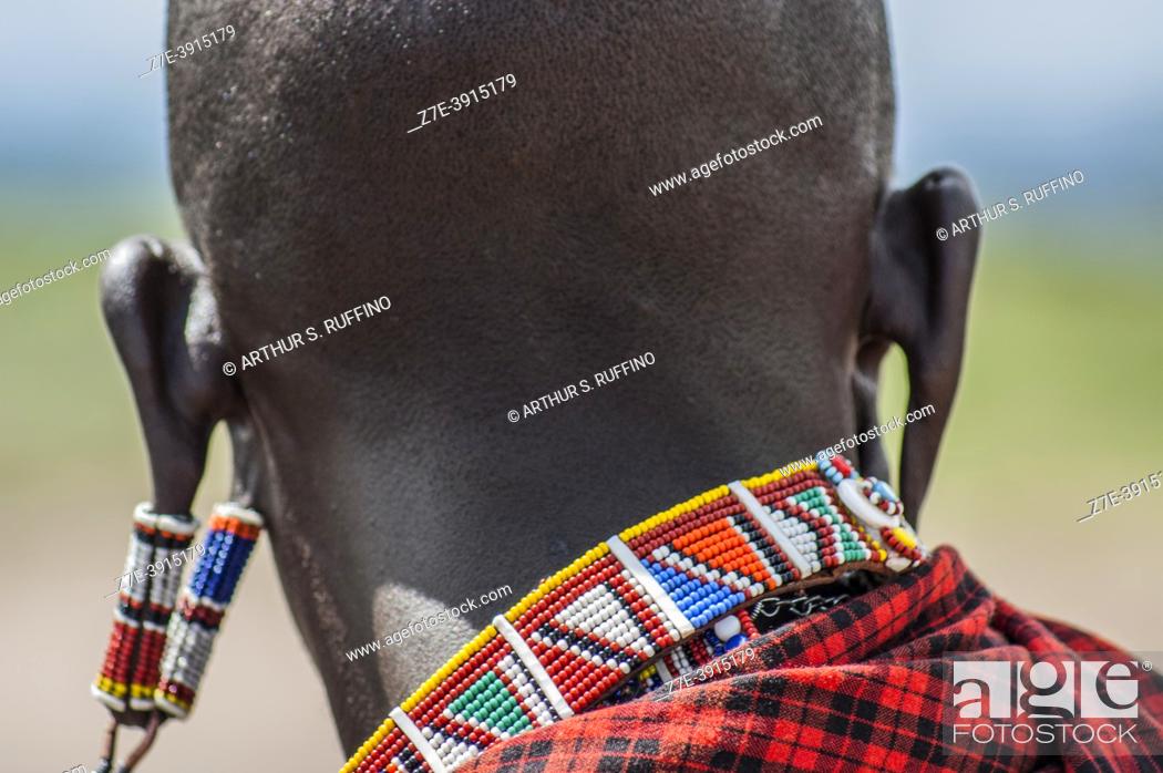 Photo de stock: Portrait detail of a Masai man with stretched earlobes wearing beaded earrings. Masai Village, Amboseli National Park, Kenya, Africa.
