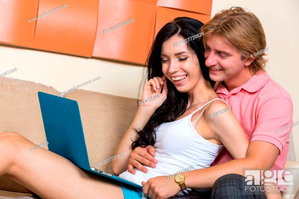 Stock Photo: Happy young couple relaxing together and making some online purchases.