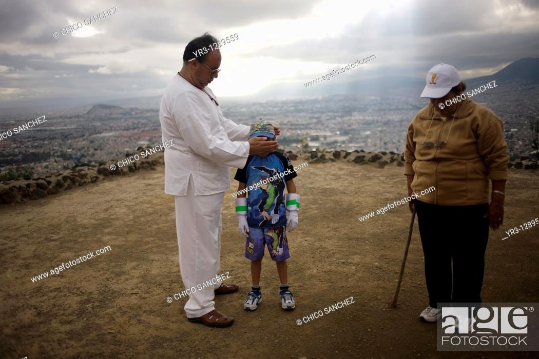 Stock Photo: A boy receives Reiki on the top of the Cerro de la Estrella Hill of the Star pyramid, Iztapalapa, with Mexico City in the background, November 23.