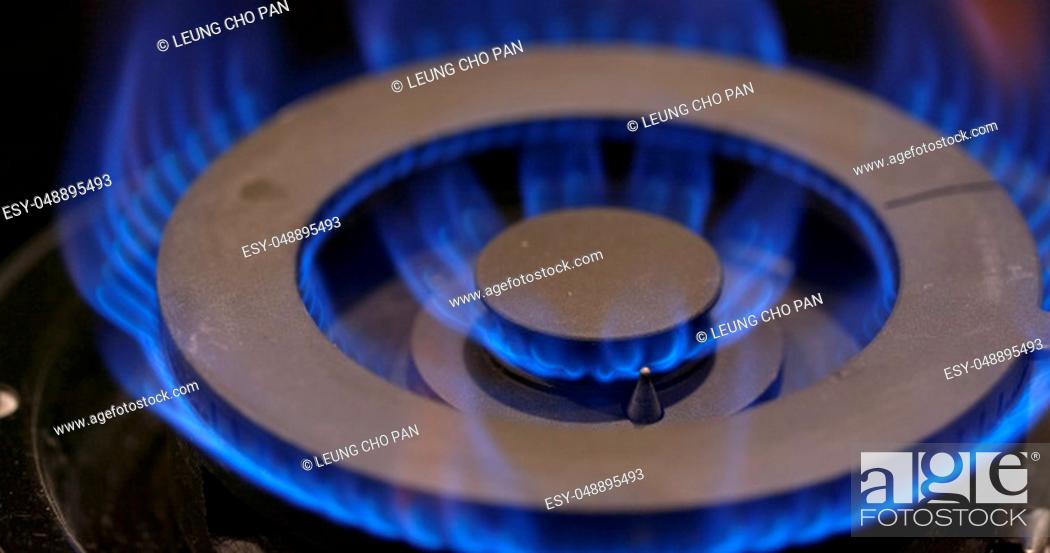 Stock Photo: Stove burner igniting into a blue cooking flame.