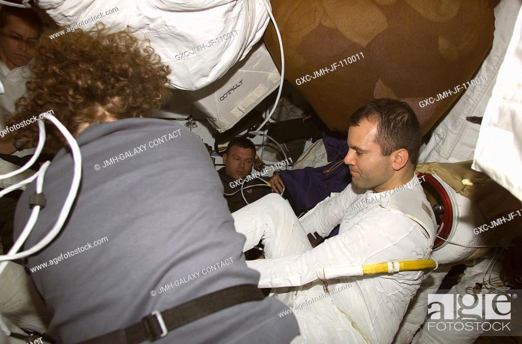 Stock Photo: Astronaut Susan J. Helms assists astronaut Paul W. Richards, mission specialist, during suit donning on Discovery's mid deck.