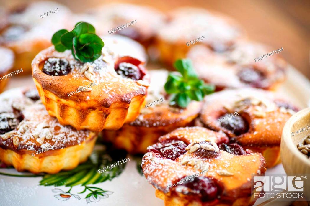 Stock Photo: cheese muffins with walnuts and cherries in the powdered sugar.