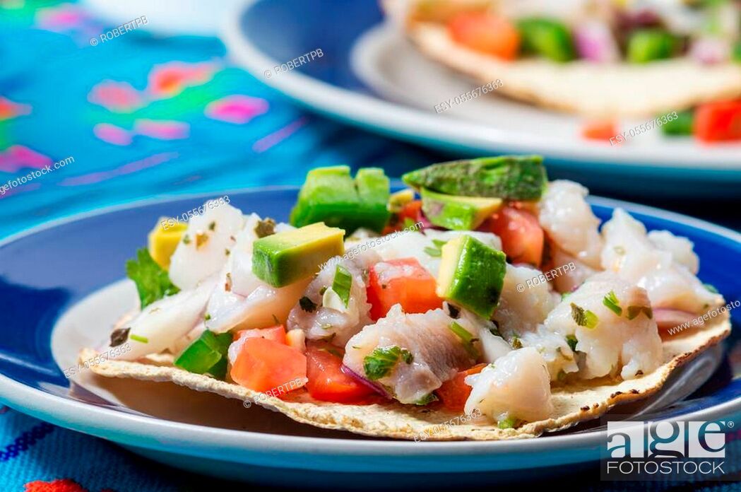 Stock Photo: Fish ceviche, Mexican food from Peruvian origin. Raw fish marinated in lime juice with raw onion, tomato, jalapeno pepper, avocado and herbs.
