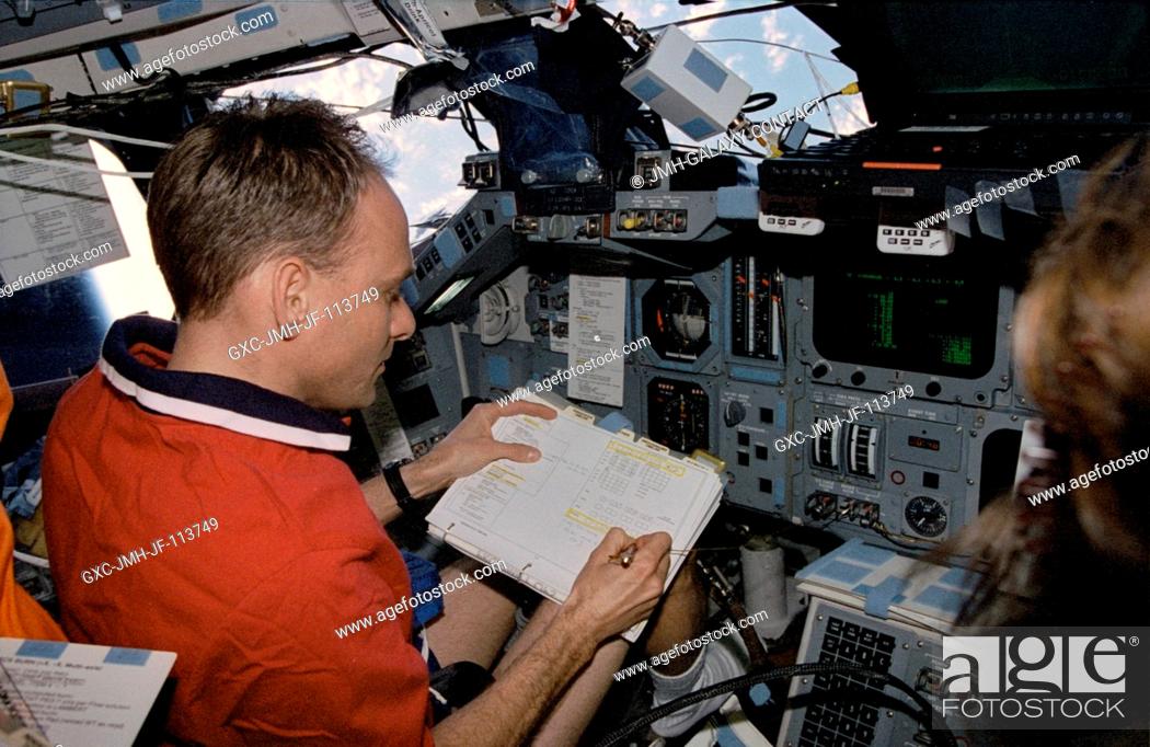 Stock Photo: Astronaut Joe F. Edwards Jr., STS-89 pilot, highlights important data on a checklist while temporarily occupying the commander's station on the port side of the.
