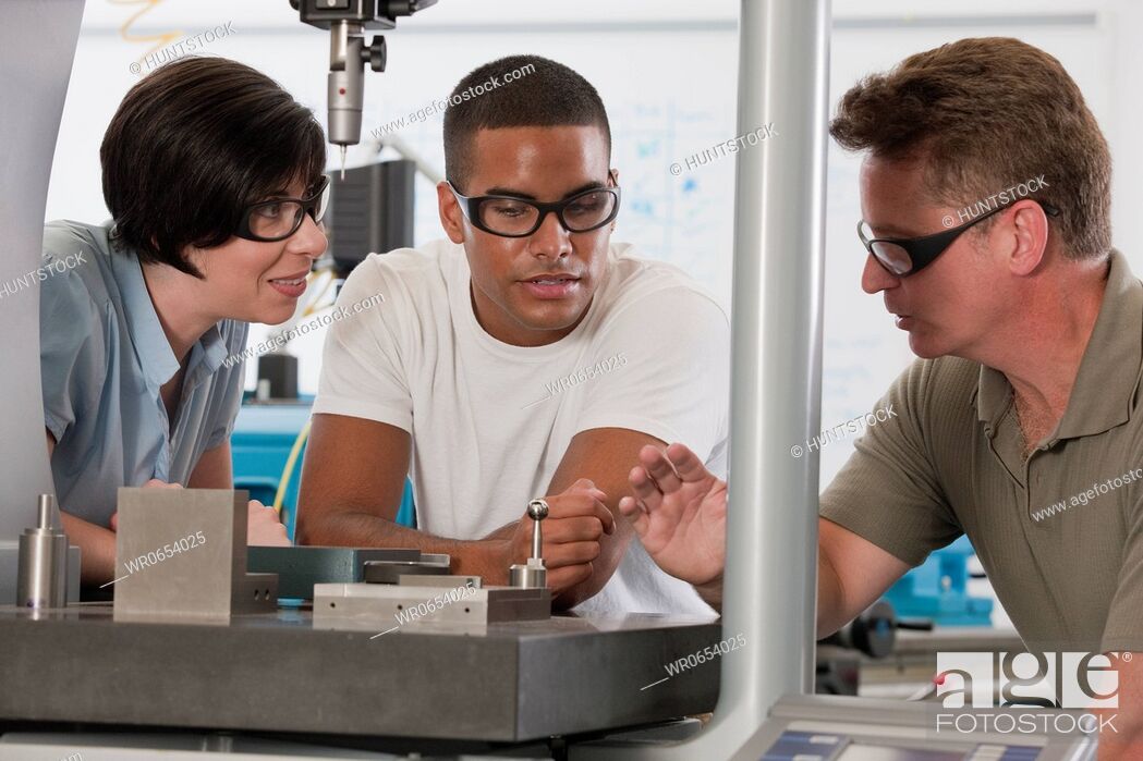 Stock Photo: Engineering professor demonstrating a coordinate measuring machine to students.