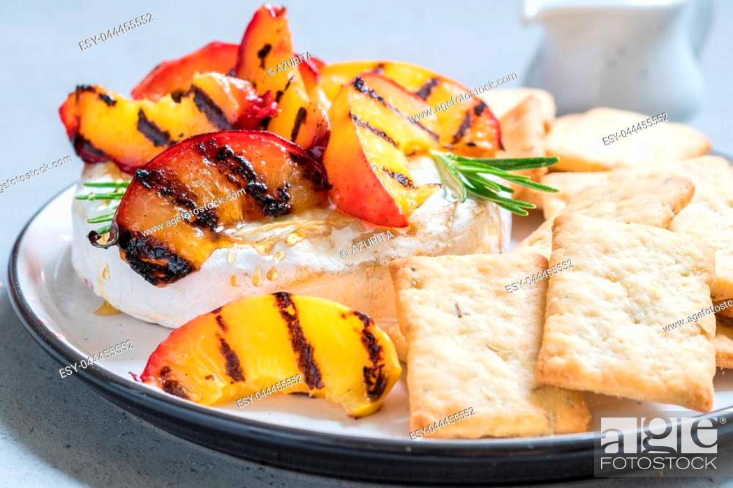 Stock Photo: Baked Camembert cheese with grilled peach and rosemary.