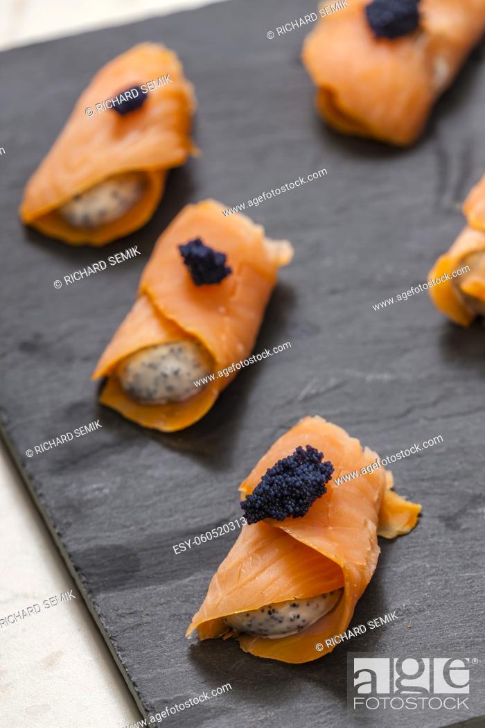 Stock Photo: smoked salmon rolls filled with cream cheese and black caviar.