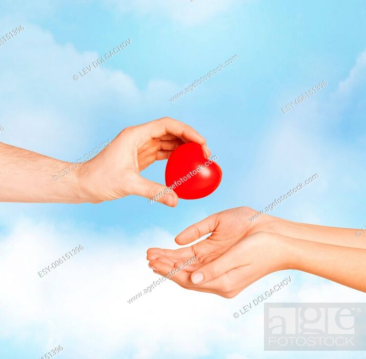 Stock Photo: love, relationship, charity and medicine concept - man hand giving red heart to woman.
