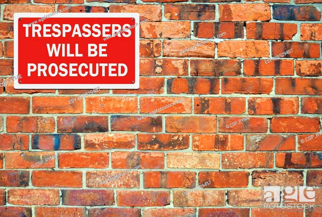 Stock Photo: 'Trespassers' will be prosecuted' sign, against brick wall. Space for your text overlay.