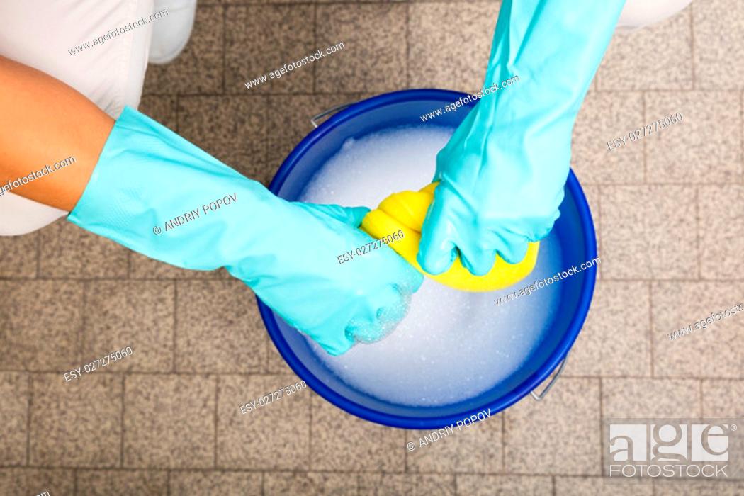 Stock Photo: Close-up Of Cleaner Woman Hand Squeezing Cloth In Bucket Filled With Soap Sud.