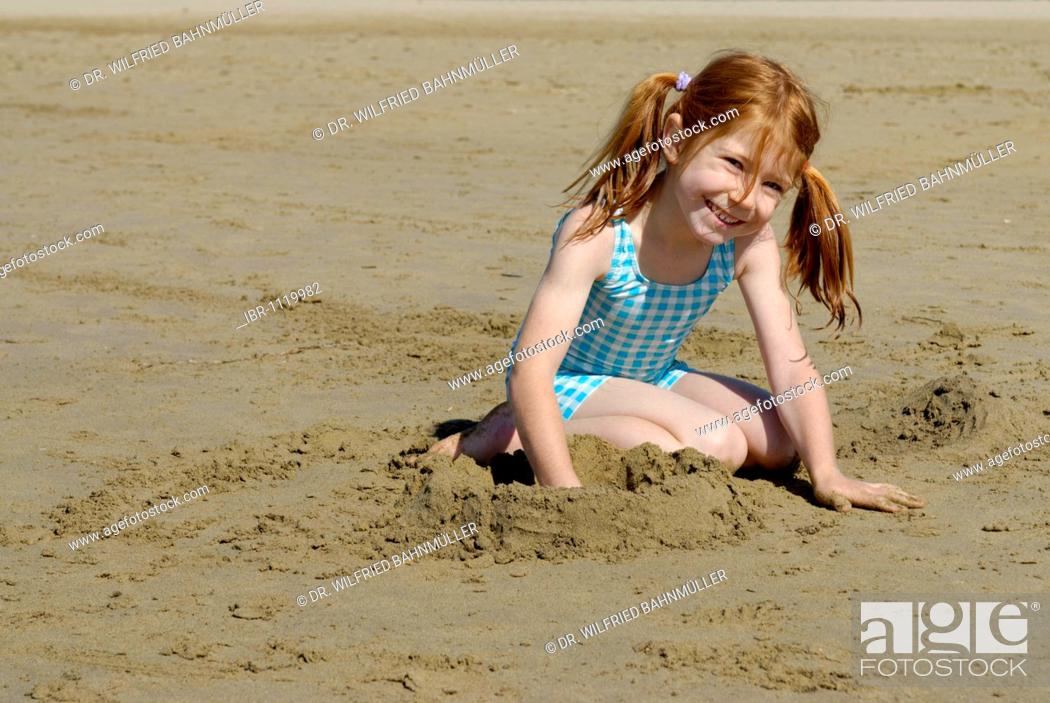 Stock Photo: Girl lying and playing on the beach, seaside of the Adria, Bibione, Venetia, Venice, Italy, Europe.