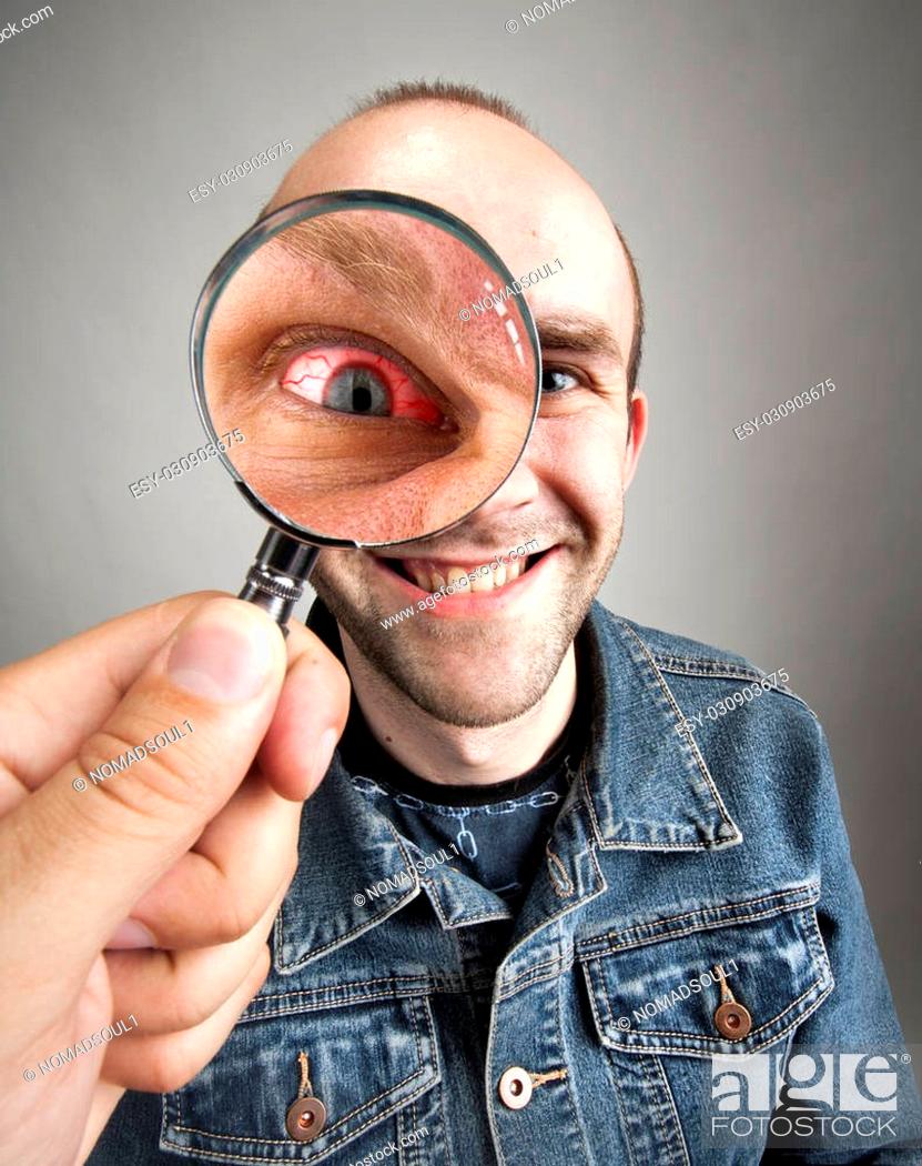 Looking to funny smiling man with angry eye through magnifying lens, Stock  Photo, Picture And Low Budget Royalty Free Image. Pic. ESY-030903675 |  agefotostock