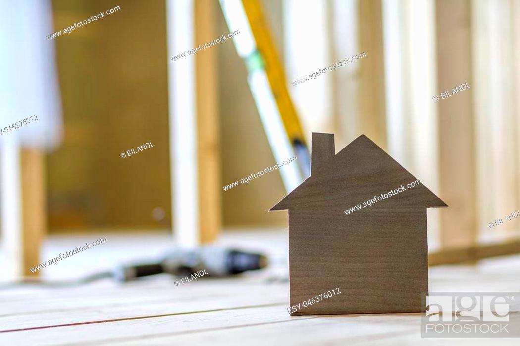 Stock Photo: Close-up of simple small brown model house on blurred building tools background. Construction, building and investments in real estate.