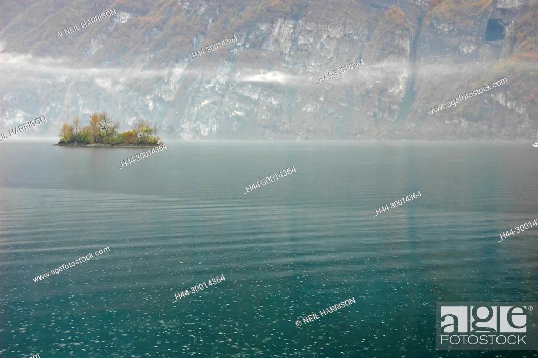 Stock Photo: Misty Lake with Island in the mountains creating a melancholy atmosphere.