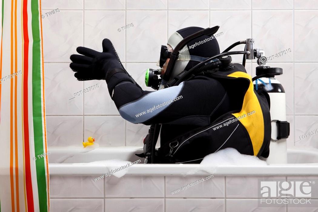 Stock Photo: A scuba diver sitting in a bathtub preparing to dive in.