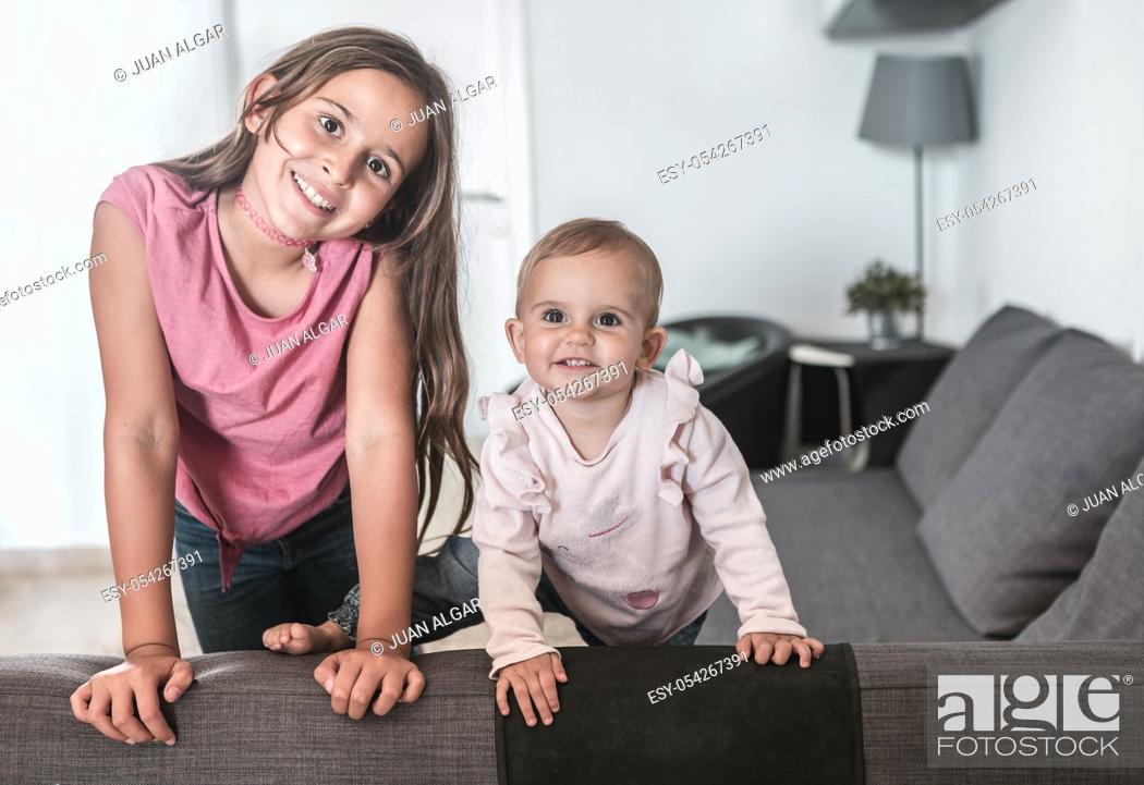 Stock Photo: Two girls smiling on the couch at home.