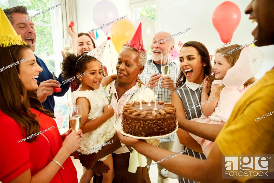 Stock Photo: Multi-generation family celebrating birthday with chocolate cake.