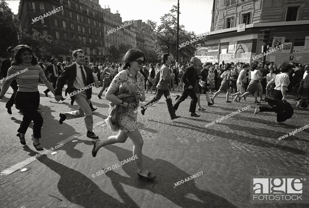 Stock Photo: The risk of a revolution in Paris has been averted. Demonstrating people are running on a boulevard of Paris, in one of the huge march through the capital town.