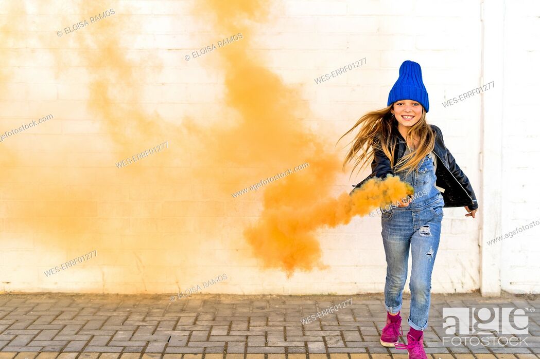Stock Photo: Portrait of smiling girl with orange smoke torch.