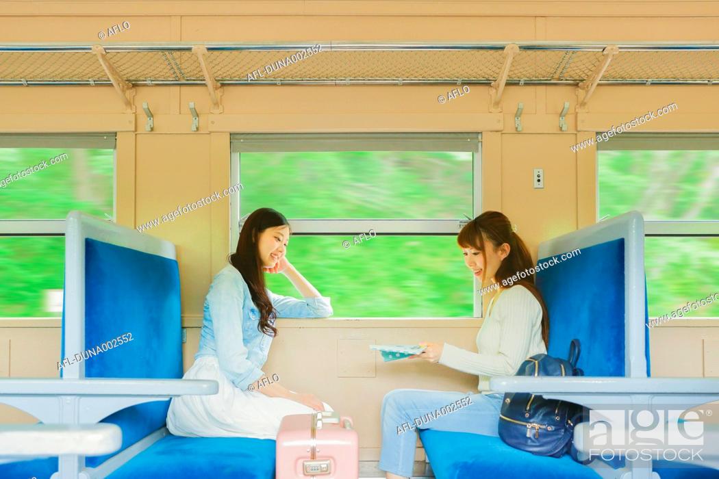 Stock Photo: Young Japanese women on a train trip.