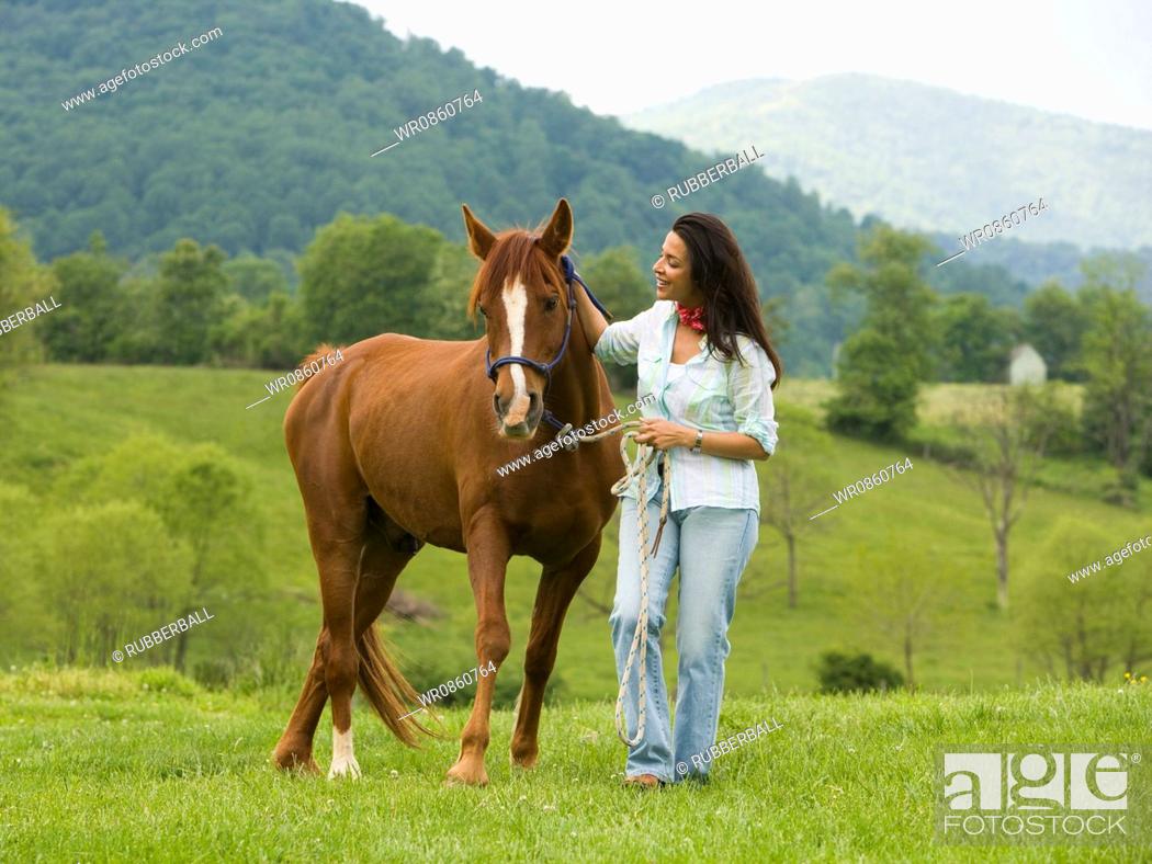 Stock Photo: woman holding the reins of a horse.