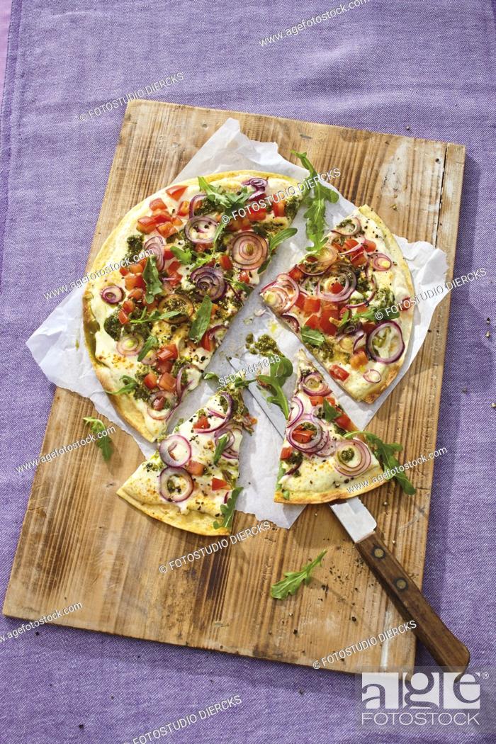 Stock Photo: Tortila pizza with rocket, onions and pesto.