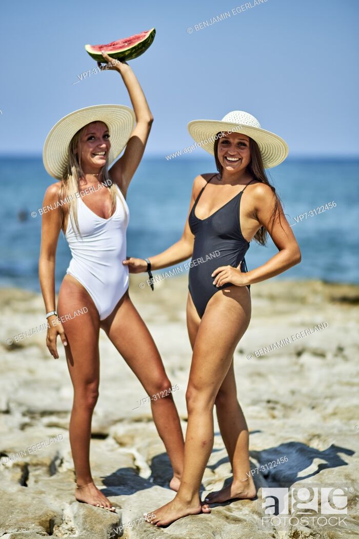 Stock Photo: Two young women with water melon and sunhats. Chersonissos, Crete, Greece.