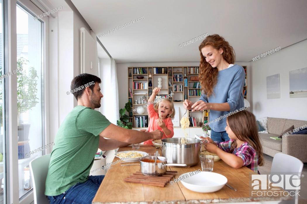 Stock Photo: Couple with two children going to have lunch together at home.