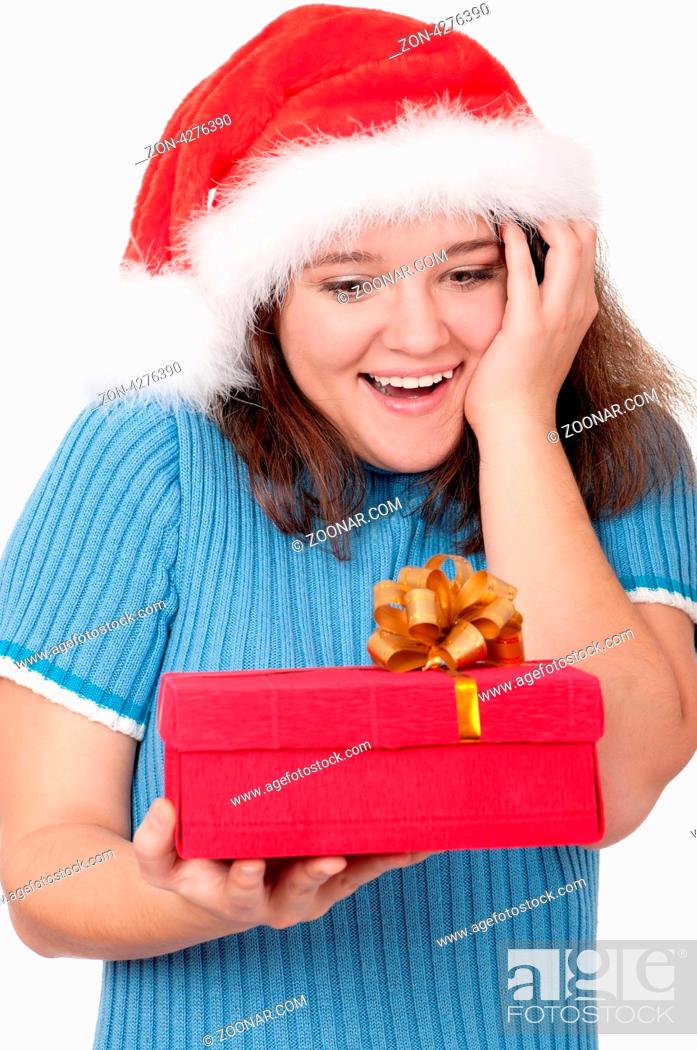 Stock Photo: Christmas girl holding gift wearing Santa hat over white background.
