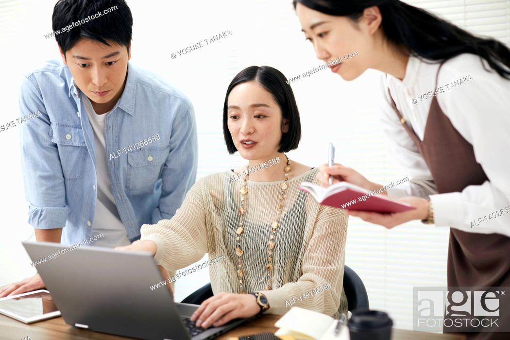Stock Photo: Japanese businesspeople working in the office.