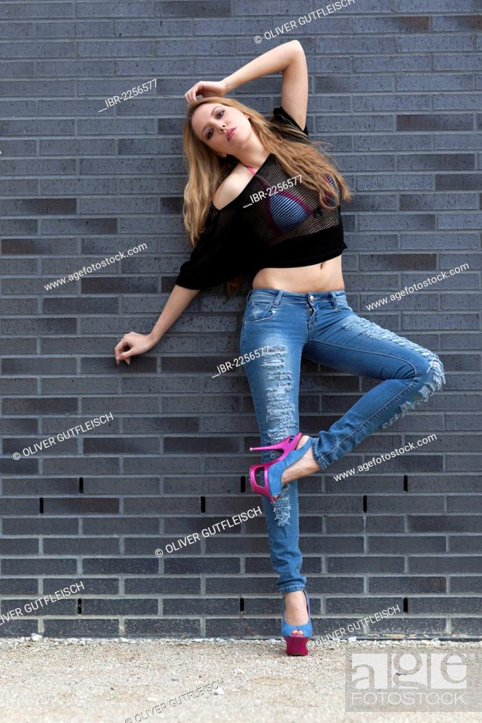 young woman poses in blue jeans shirt