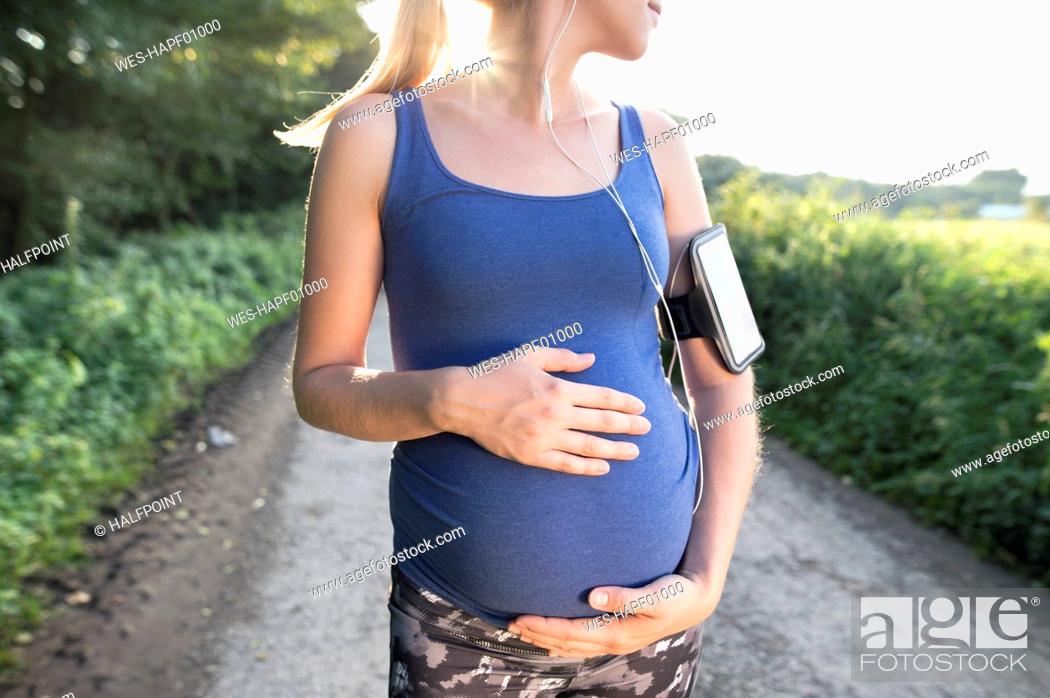 Stock Photo: Pregnant woman taking a break from jogging.